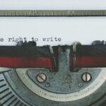 Close-up of a vintage typewriter with 'the right to write' typed on paper.